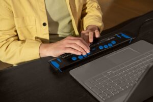 man gebruikt brailleleesregel in combinatie met laptop