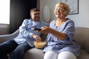 Koppel kijkt samen tv en eet popcorn